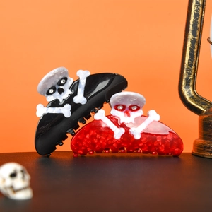Close-up of Halloween skull hair claws with sparkling rhinestones on an orange background