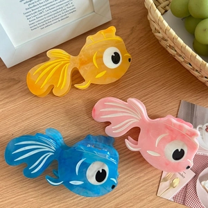 Three acetate shark clips in goldfish shapes with marble texture in orange, pink, and blue