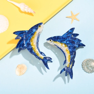 Dettaglio di fermagli per capelli a forma di pesce volante blu e giallo in acetato