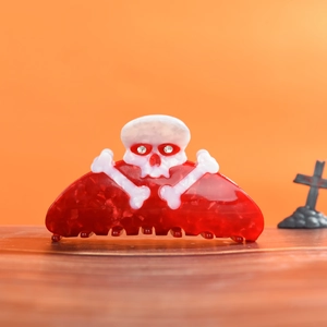 Detail of Halloween skull hair claw clip in deep red marble acetate with rhinestone eyes