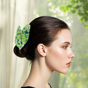 Leaf-shaped acetate hair claw clip with multicolor leaf patterns on woman's hair
