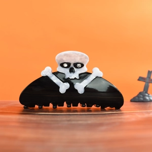Detail of Halloween hair claw with skull and crossbones design on black acetate