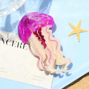 Dettaglio di un fermaglio per capelli in acetato a forma di medusa con decori marini