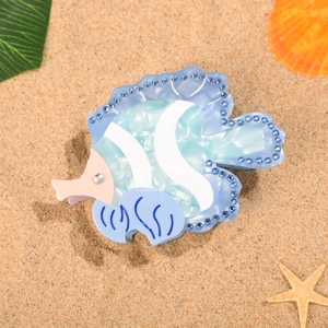 Pince à cheveux poisson tropical avec strass bleus sur fond de plage d'été