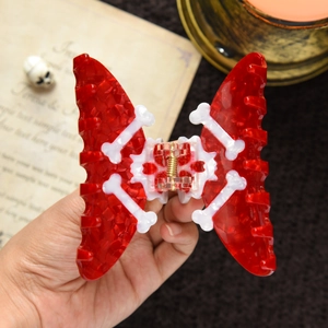 Detail of red butterfly hair claw clip with white bone pattern for Halloween theme
