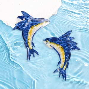 Mollette per capelli a forma di pesce volante blu scuro su sfondo d'acqua increspata