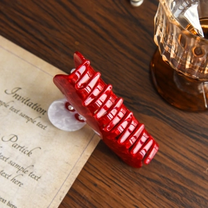 Macro detail of red acetate hair claw clip with marble texture and sturdy metal spring