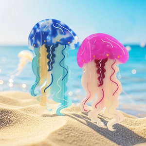 Molle per capelli a forma di medusa in acetato blu e rosa marmorizzato sulla sabbia