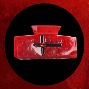 Détail de la pince à cheveux rouge marbré avec cristaux et croix noire gothique