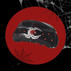 Détail d'une pince à cheveux araignée gothique avec strass rouges sur fond de toile