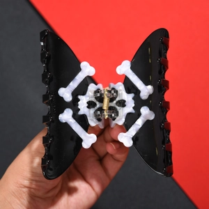 Gothic butterfly hair claw clip with skull bone patterns and golden spring detail