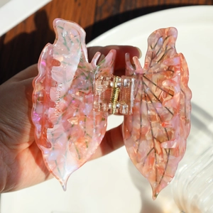 Detail of pink leaf hair claw clip made of cellulose acetate with marble texture