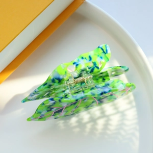 Close-up of marble pattern acetate butterfly hair claw clip in vibrant green and blue