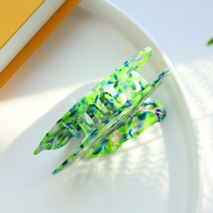Close-up of multi-color leaf pattern hair claw clip with emerald green and blue accents