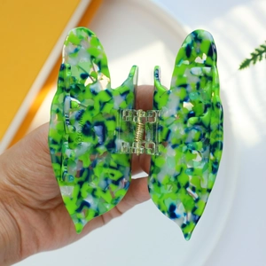 Detail of butterfly hair claw with marble texture acetate and gold spring mechanism