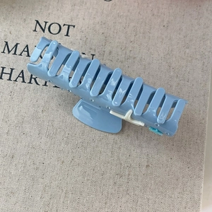 Detalle de pinza para el pelo en acetato azul claro con acabado brillante y adorno