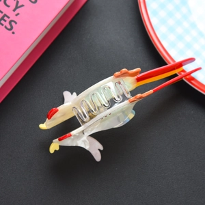 Dettaglio di un fermaglio per capelli a forma di gallo in acetato finitura perlata