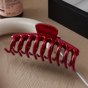 Detailed view of durable burgundy silicone shark hair claw clip with glossy finish