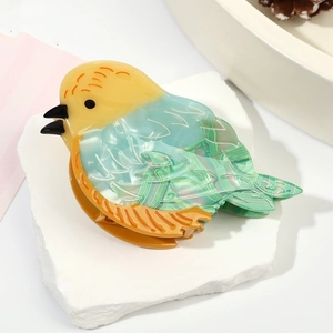 Détail d'une pince à cheveux en forme d'oiseau en acétate avec finition nacrée