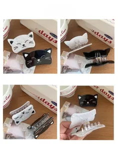 Détail des pinces à cheveux chat en acrylique montrant le motif frontal et le clip à ressort