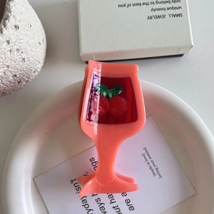 Creative coral pink wine glass hair claw clip with cherry motif in a ceramic dish