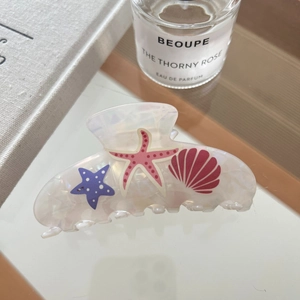 Detailed close-up of acetate starfish hair claw clip with colorful ocean patterns