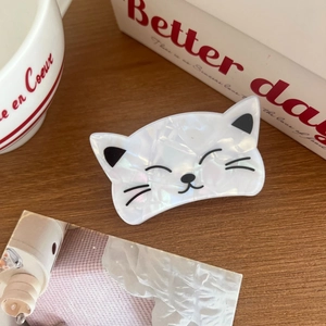 Détail d'une pince à cheveux en forme de chat avec texture nacrée irisée et accents noirs