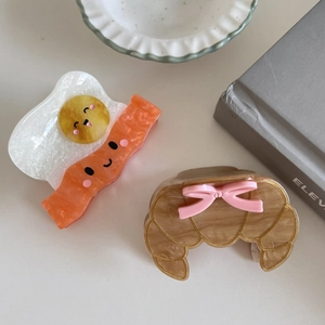 Creative food-shaped hair claw clips featuring croissant and bacon egg designs in 2-pack set