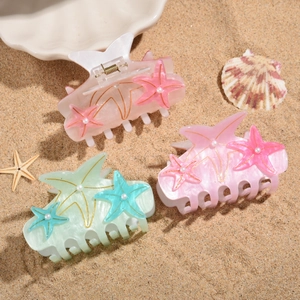 Starfish hair claws with pearls in pink and mint green on a beach background