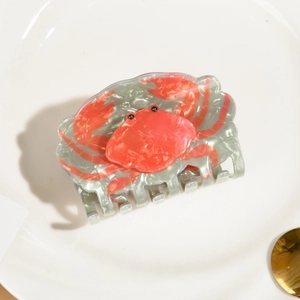 Détail de la pince à cheveux crabe en acétate avec texture marbrée et perles