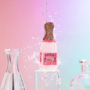 Pink champagne bottle hair claw clip with gold glitter in dynamic water splash