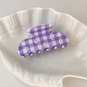 Detailed close-up of plaid purple hair claw clip with white daisies and tiny rhinestones
