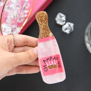Pink champagne bottle hair claw clip with golden glitter and elegant crown design