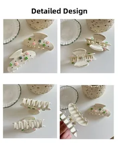 Detail view of cream hair claws with colorful flowers and rhinestone accents