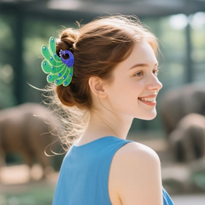 Peacock hair claw clip with blue rhinestones worn on a model in an outdoor setting