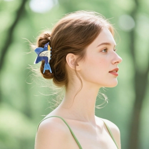 Cute bird-shaped hair claw clip with blue and yellow accents worn on a bun hairstyle