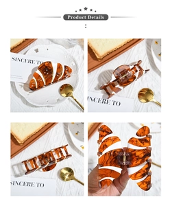 Detalles macro de la pinza para el pelo croissant con rayas ámbar y pedrería brillante