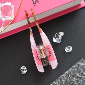 Close-up of pink marble hair claw clip with golden glitter accents and resin texture
