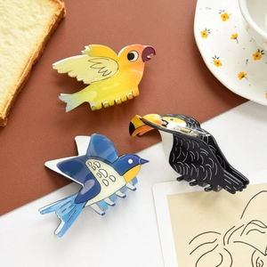 Detailed view of colorful bird-shaped hair claws on a cozy breakfast tabletop setting