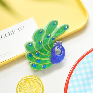 Close-up of peacock hair claw clip with colorful acetate finish and sparkling rhinestones
