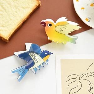 Cute bird-shaped hair claws in colorful acetate with glossy finish and parrot design