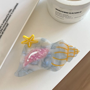 Detailed view of ocean conch hair claw clip with marble texture and starfish accent