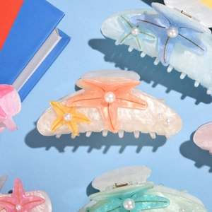 Close-up of starfish claw clips with pearl accents and glossy resin shells