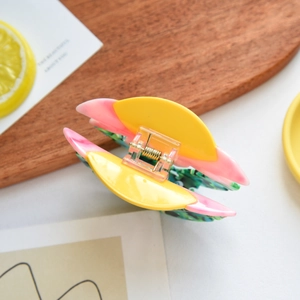 Dettaglio di un fermaglio per capelli in acetato con girasole e molla metallica