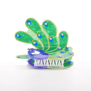 Macro view of peacock hair claw clip with green marble texture and sparkling rhinestones