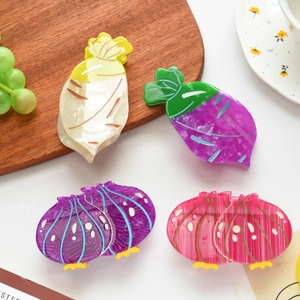 Vue détaillée de pinces à cheveux en acétate en forme de légumes, oignon et radis