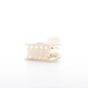 Detail view of cream acetate square hair claw clip with colorful fruit print and gold spring