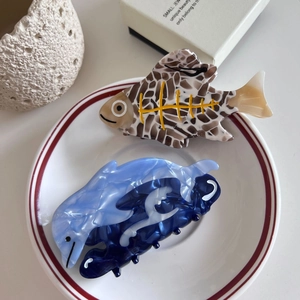 Handmade animal-shaped acetate hair claws featuring blue marble and fish bone patterns