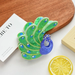 Exquisite peacock-shaped hair claw clip with blue and green crystals for elegant styling