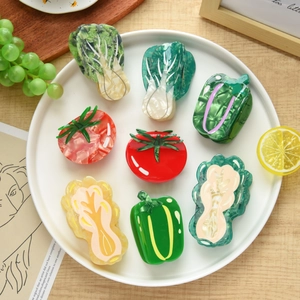 Detailed close-up of acetate hair claws in various creative vegetable shapes on a plate